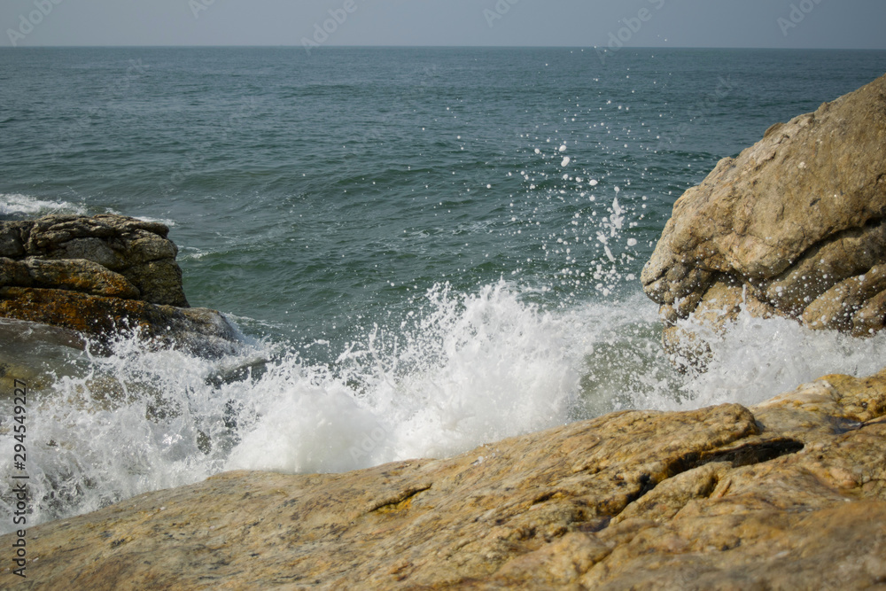 Strong waves breaking on the shore with sea foam Strong waves breaking on the shore with sea foam