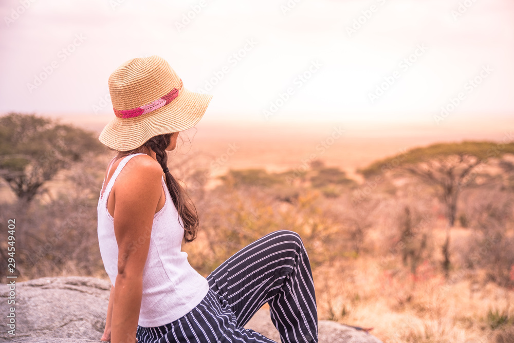 Φωτογραφία Girl at view point looking to the bush savannah of Serengeti at sunset, Tanzania