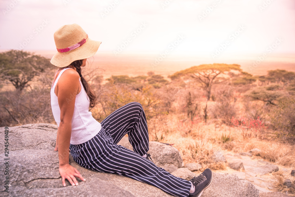 Φωτογραφία Girl at view point looking to the bush savannah of Serengeti at sunset, Tanzania