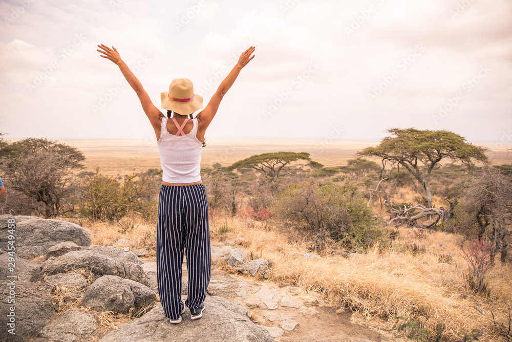 Φωτογραφία Girl at view point looking to the bush savannah of Serengeti at sunset, Tanzania