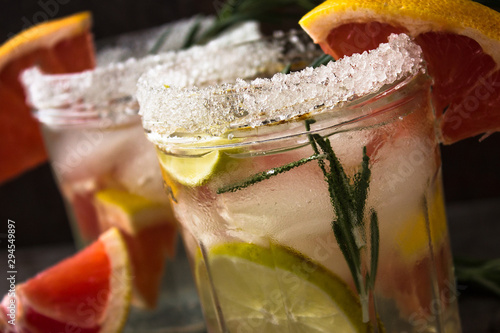 lemonade with ice, mint and paper straw in sparkling glasses on gray table background, christmas cocktail  photo