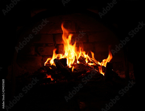 Burning wood in the fireplace, Wood burning in a cozy fireplace at home in interior. Fireplace as a piece of furniture. Christmas New Year concept decorations.