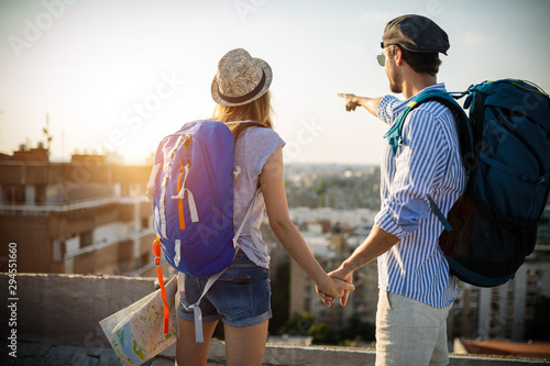 Multiethnic traveler couple using map together on sunny day