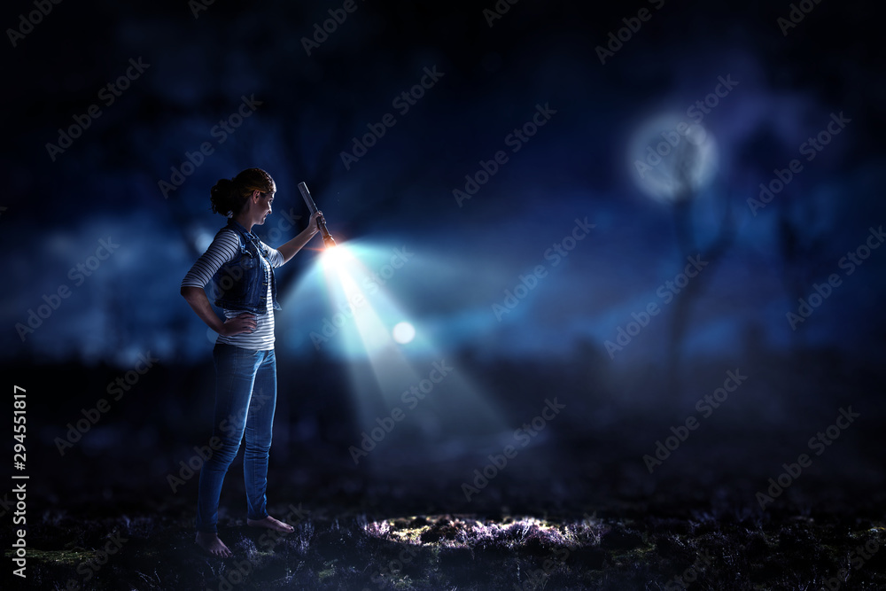 Obraz premium Young woman holding a flashlight