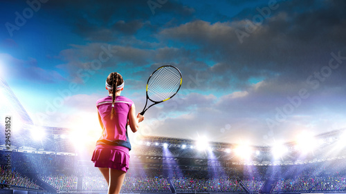 Young woman playing tennis on a stadium © Sergey Nivens