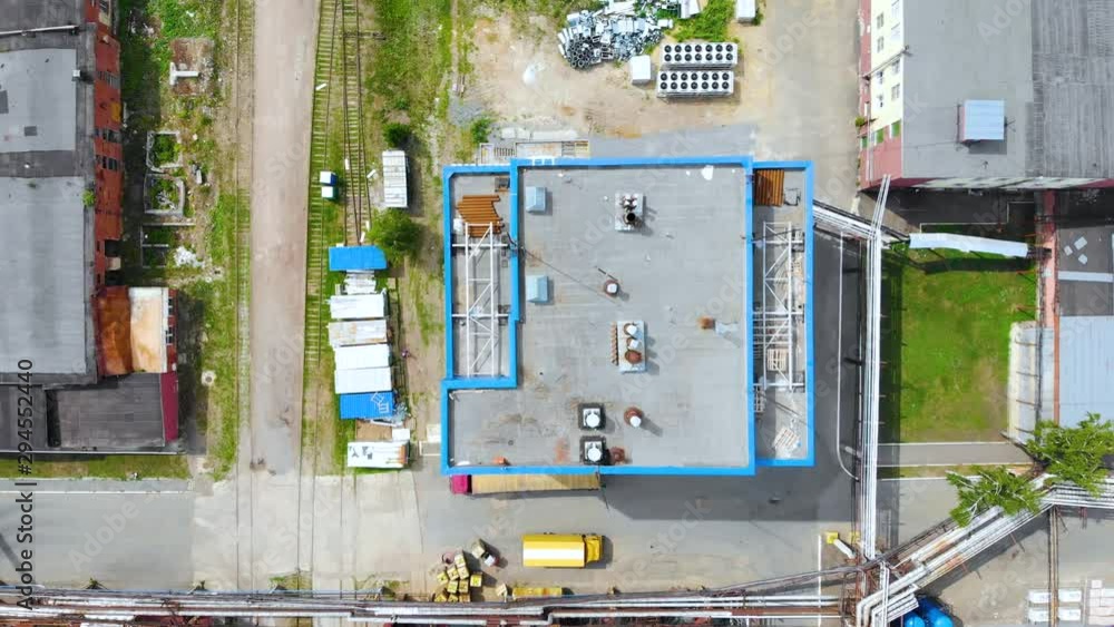 Aerial flying rise above the industrial factory. Roofs of buildings, communications and pipes, roads and rails are visible on the territory of the factory. Taken by drone, looking down Aerial flying rise above the industrial factory. Roofs of buildings, communications and pipes, roads and rails are visible on the territory of the factory. Taken by drone, looking down
