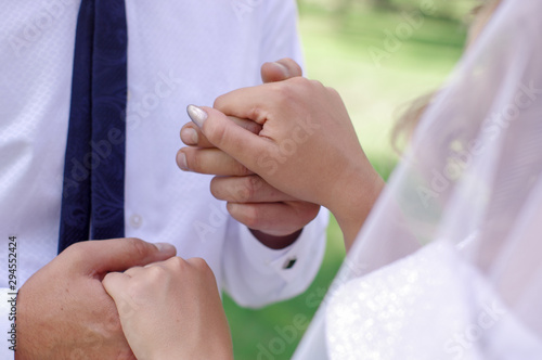 The hands of the bride and groom. Hands in the lock. The groom holds the hand of the bride tightly. Wedding day