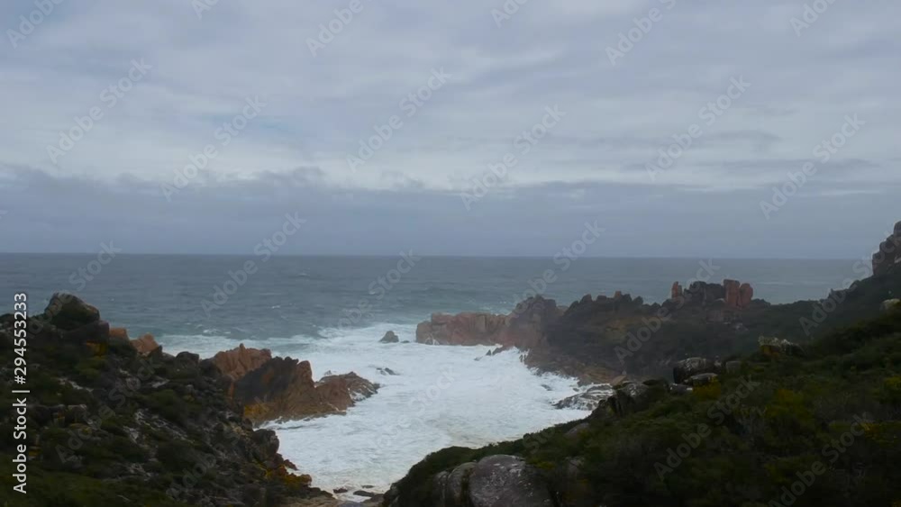 Aerial slow motion: Wave crash over the rocks at a secluded bay beach Aerial slow motion: Wave crash over the rocks at a secluded bay beach