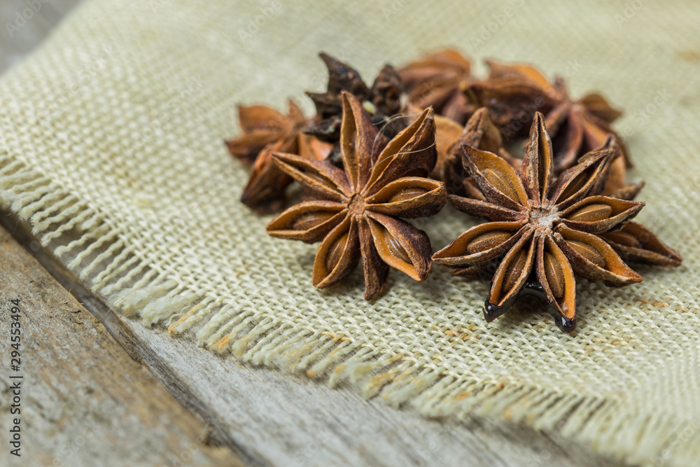 Heap of anise stars, isolated on wooden background