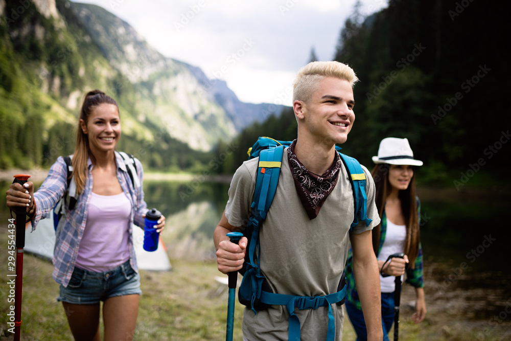 Trekking, camping, hiking and wild life concept. Group of friends are hiking in nature - obrazy, fototapety, plakaty 
