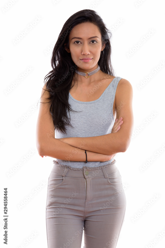 Studio shot of young beautiful Asian woman standing with arms cr Studio shot of young beautiful Asian woman standing with arms cr