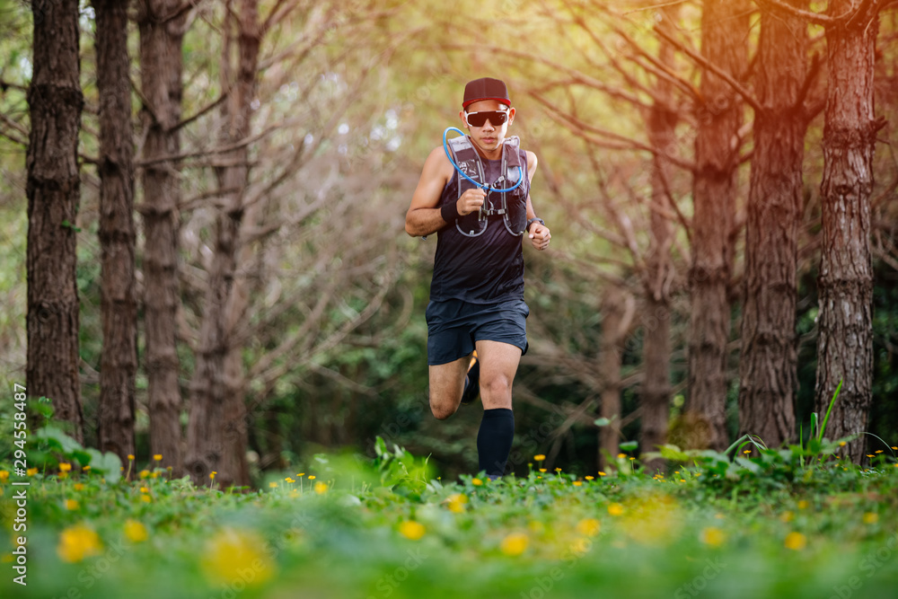 A man Runner of Trail and athlete's feet wearing sports shoes for trail running in the forest A man Runner of Trail and athlete's feet wearing sports shoes for trail running in the forest