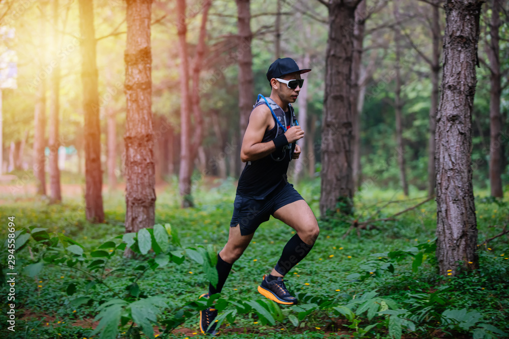 A man Runner of Trail and athlete's feet wearing sports shoes for trail running in the forest