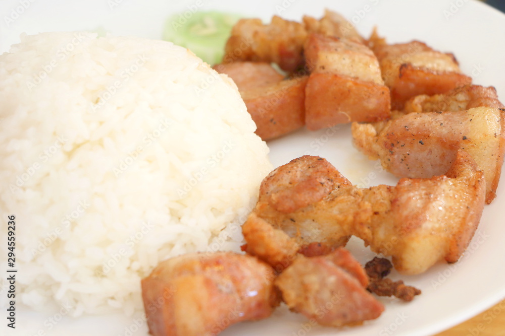 Close up deep fried belly pork with salt with jasmine rice in white plate Close up deep fried belly pork with salt with jasmine rice in white plate