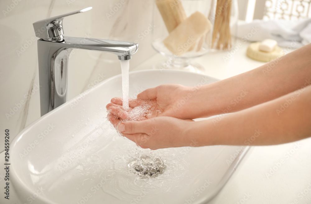 Woman washing hands indoors, closeup. Bathroom interior Woman washing hands indoors, closeup. Bathroom interior
