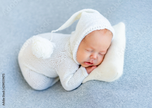 Sleep of newborn in white bodysuit