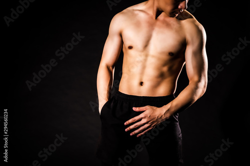sport man standing showing muscle bodybuilding on black backgrounds  fitness concept  sport concept