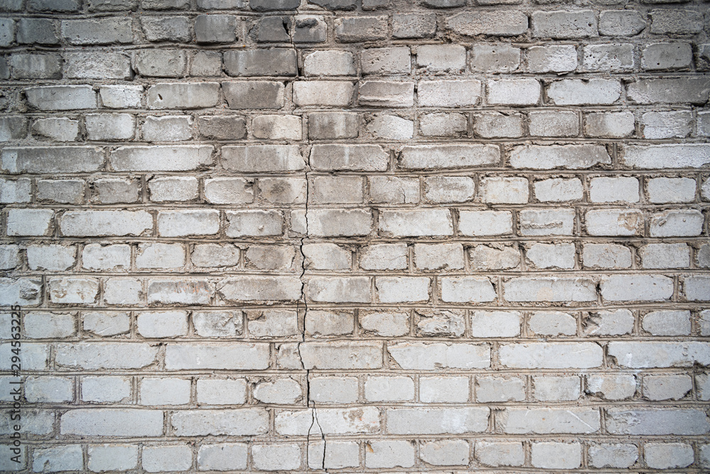 Obraz premium Shabby light brick wall texture with crack