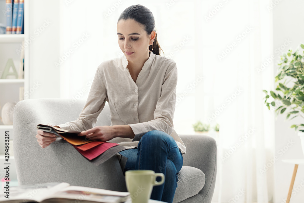 Young woman choosing the best upholstery for the armchair Young woman choosing the best upholstery for the armchair