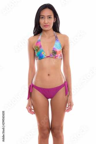 Studio shot of young beautiful Asian woman wearing bikini