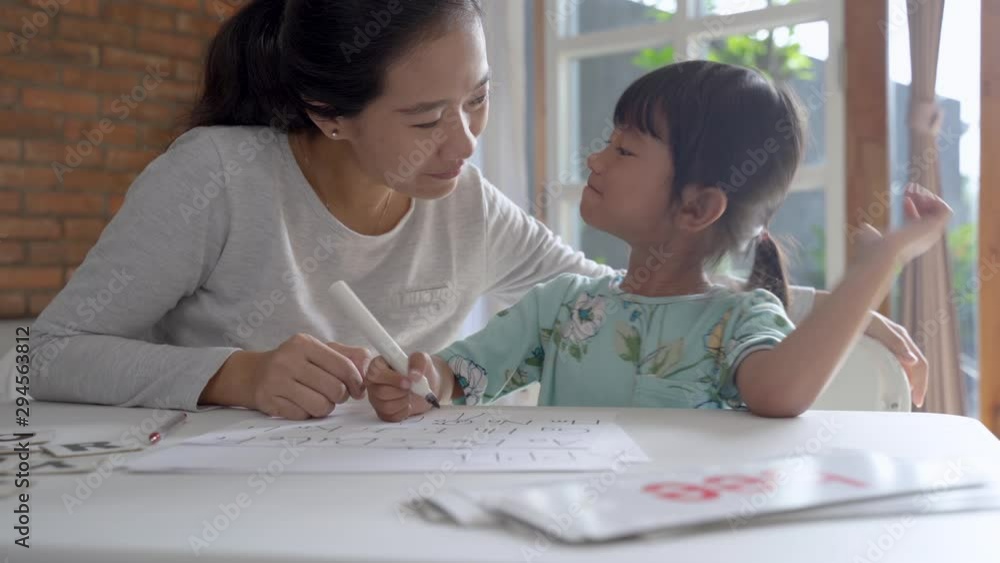 happy mother teaching her daughter the basic to read and write at home. toddler kindergarten student happy mother teaching her daughter the basic to read and write at home. toddler kindergarten student