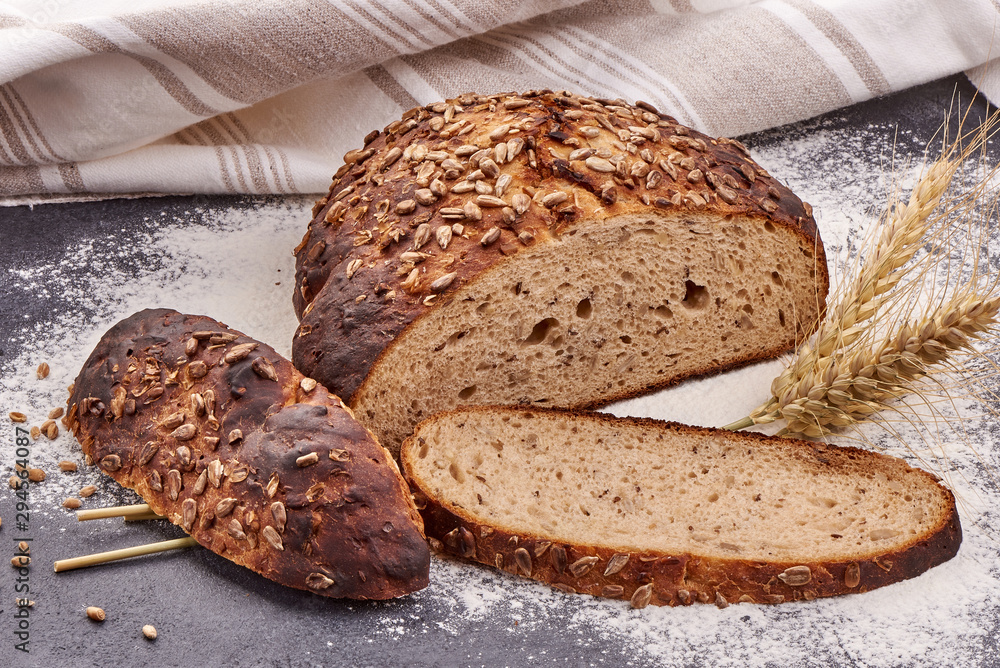 Naklejka premium Round freshly baked rustic rye bread on a rustic background