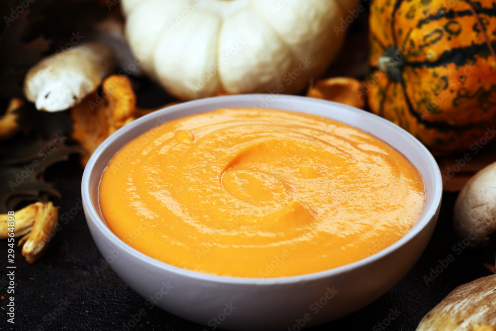 Roasted pumpkin and carrot soup with cream and pumpkin seeds on wooden background. Roasted pumpkin and carrot soup with cream and pumpkin seeds on wooden background.