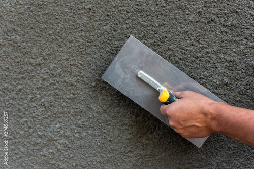 Fotografie Application of decorative plaster on wall using construction tool