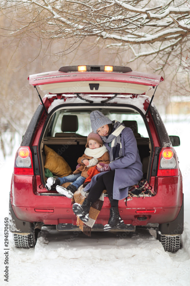 Caucasian mom with daughter with thermos in trunk Caucasian mom with daughter with thermos in trunk