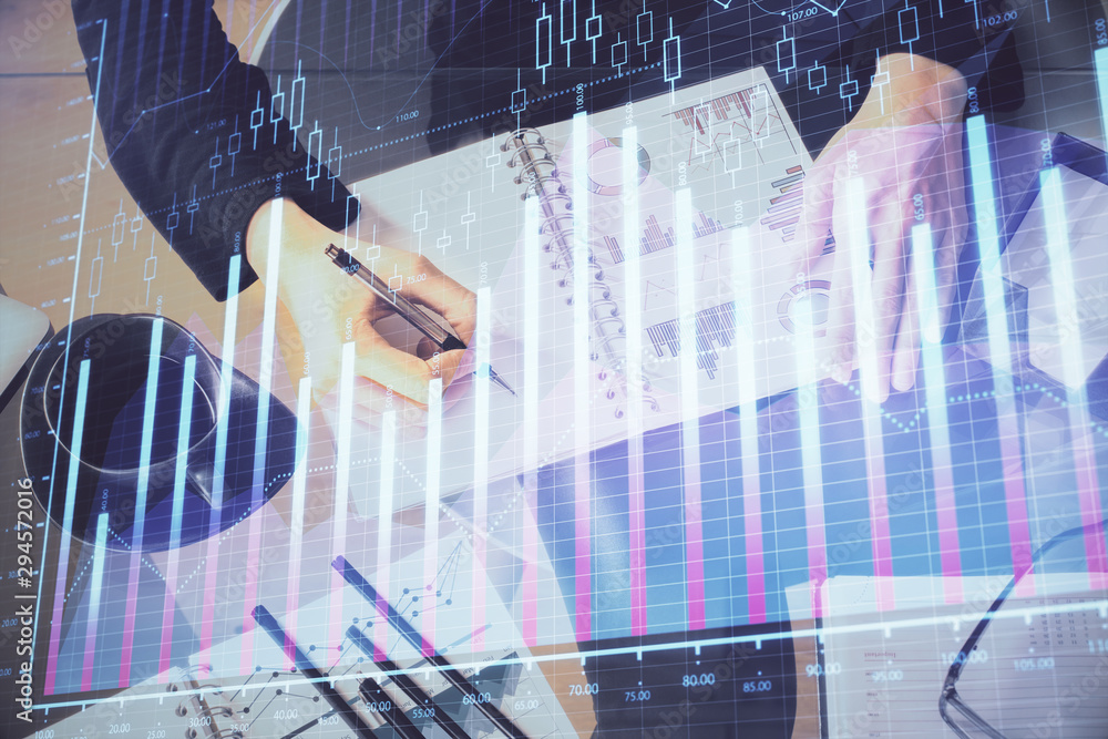 Multi exposure of hands making notes with forex chart huds. Stock market concept. Multi exposure of hands making notes with forex chart huds. Stock market concept.