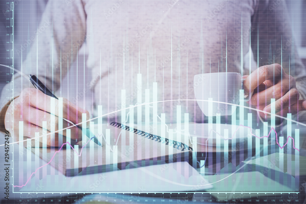 Forex chart hologram on hand taking notes background. Concept of analysis. Double exposure Forex chart hologram on hand taking notes background. Concept of analysis. Double exposure