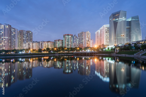 Buildings with reflections on lake at twilight at Thanh Xuan park. Hanoi cityscape at twilight period © Hanoi Photography