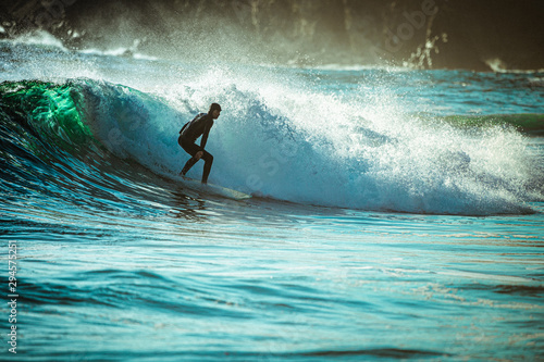 Photography Guy surfing in sunset on pacific beach coast in big sur california