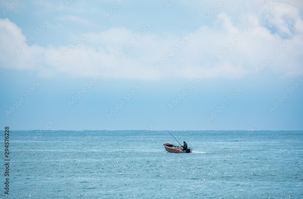 A fisherman is sailing in a boat. A fisherman is sailing in a boat.