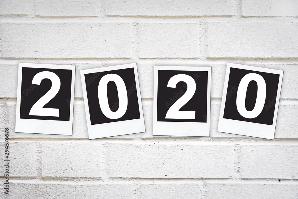 2020 in instant photo frames on a brick wall, new year greeting card 2020 in instant photo frames on a brick wall, new year greeting card