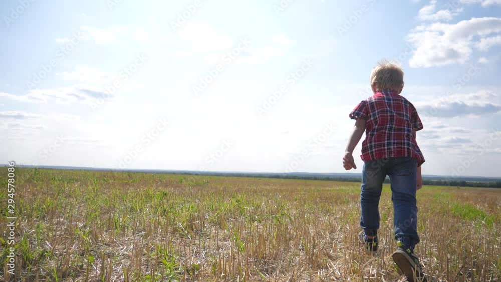 happy family concept little boy runs. boy schoolboy runs across the field in nature slow motion video. childhood dreams of lifestyle freedom superhero happy family concept little boy runs. boy schoolboy runs across the field in nature slow motion video. childhood dreams of lifestyle freedom superhero