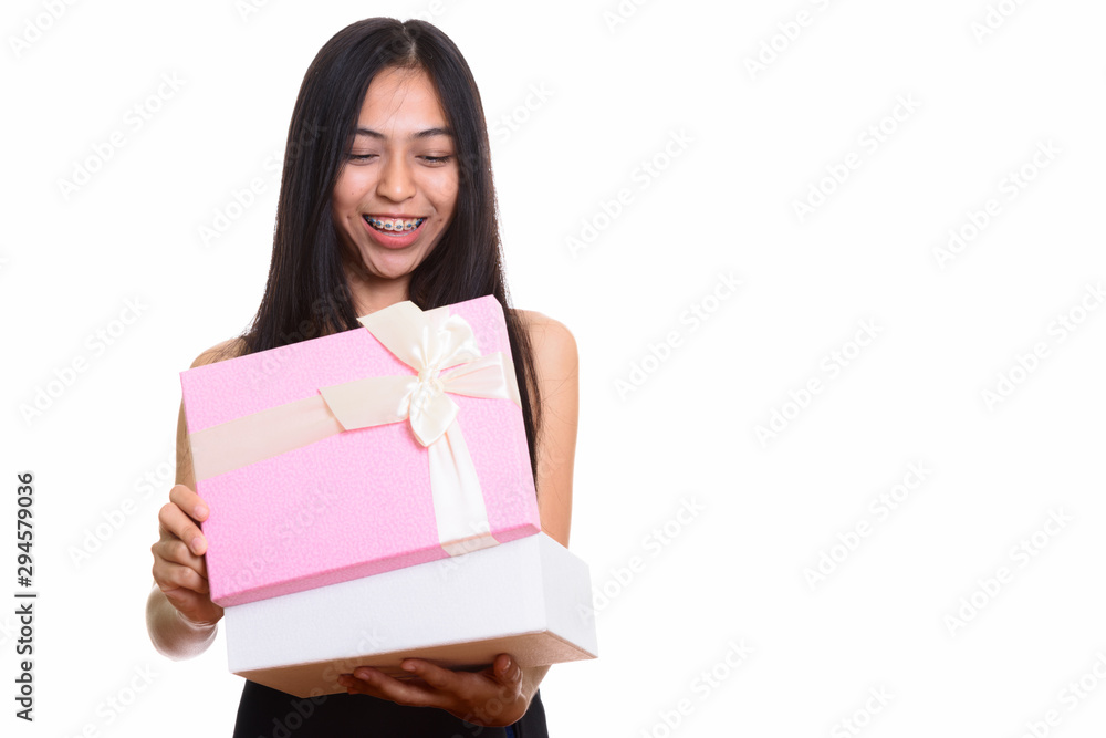 Studio shot of young happy Asian teenage girl smiling while open Studio shot of young happy Asian teenage girl smiling while open