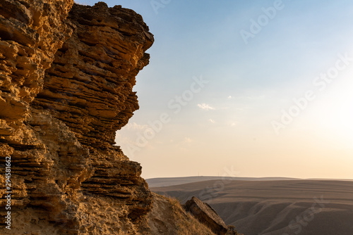 Cliff of sedimentary rocks against the blue sky photo