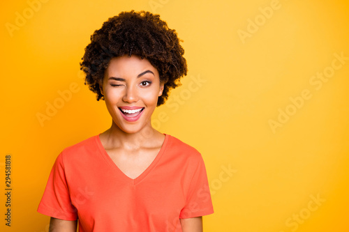 Copyspace photo cheerful cute charming nice fascinating girlfriend winking for you to pay attention while isolated over yellow vivid color background