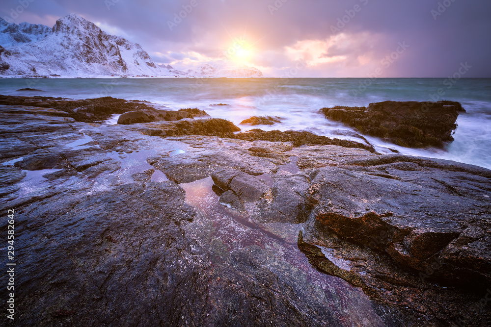 Coast of Norwegian sea on rocky coast in fjord on sunset