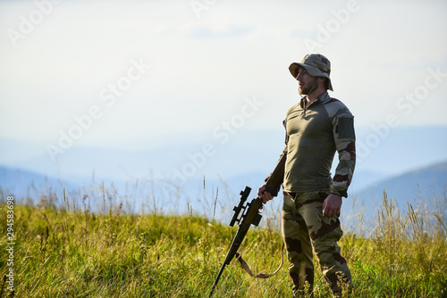 Focus and concentration experienced hunter. Brutal warrior. Rifle for hunting. Hunter hold rifle. Hunter mountains landscape background. Ready to shoot. Army forces. Man military clothes with weapon