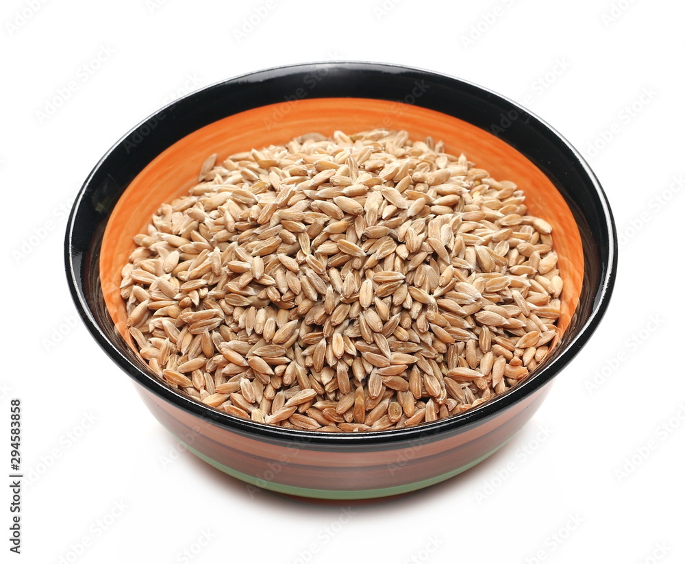 Spelt grains in colorful clay pot, bowl isolated on white background