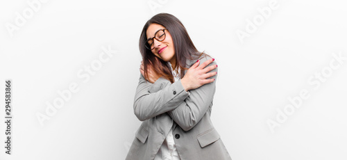 Konstfotografi young pretty woman feeling in love, smiling, cuddling and hugging self, staying