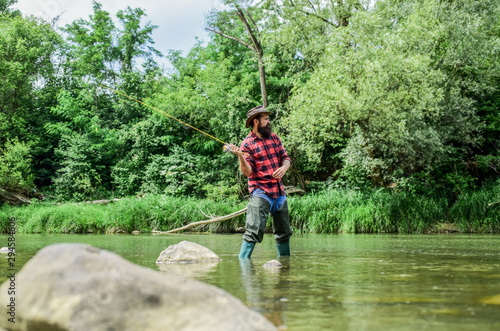 Man bearded fisherman. Fisherman fishing equipment. Hobby sport activity. Fish farming pisciculture raising fish commercially. River lake lagoon pond. Trout farm. Fisherman alone stand in river water