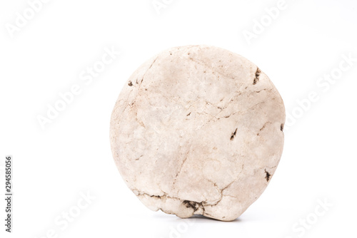 A picture of a single stone in the shape of a natural sphere on a white area. © yongyut