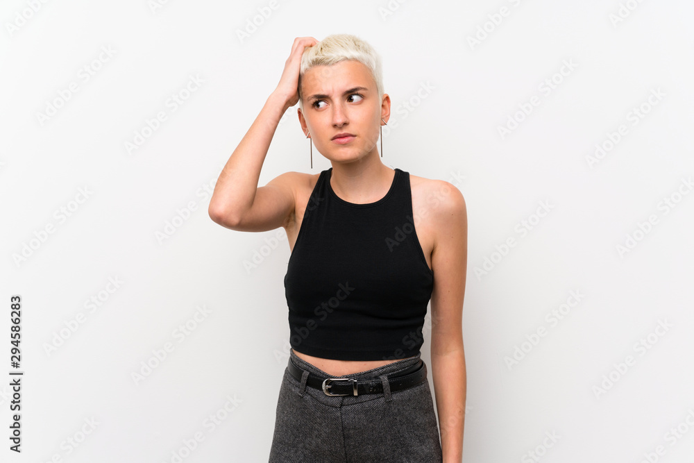 Teenager girl with short hair over white wall having doubts while scratching head Teenager girl with short hair over white wall having doubts while scratching head