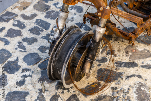 Fototapeta Naklejka Na Ścianę i Meble -  Burned motorcycle on the street detail of the front wheel