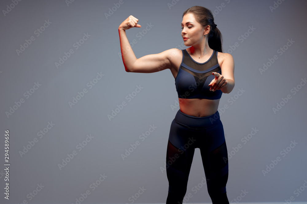 Healthy fit young woman in sportswear standing over a gray background Healthy fit young woman in sportswear standing over a gray background