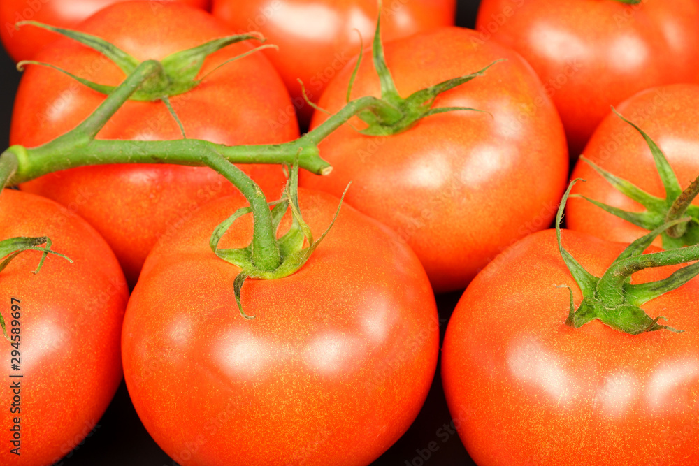 Several fresh juicy red bunch tomatoes on black background Several fresh juicy red bunch tomatoes on black background