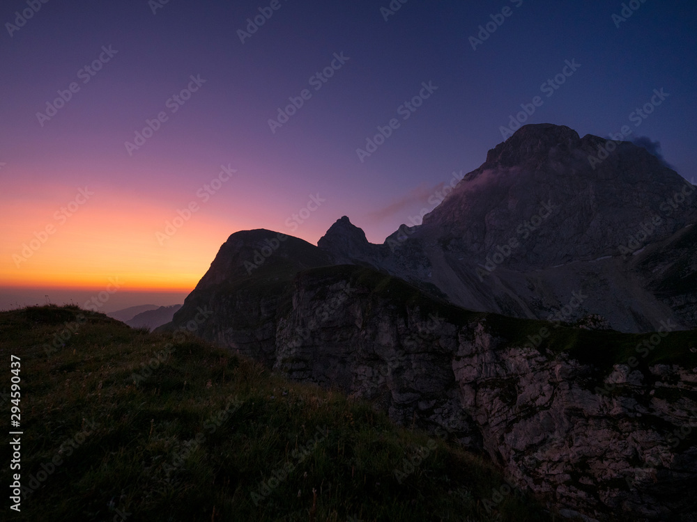 SILHOUETTE: Breathtaking view of the misty mountains from a summit in the Alps